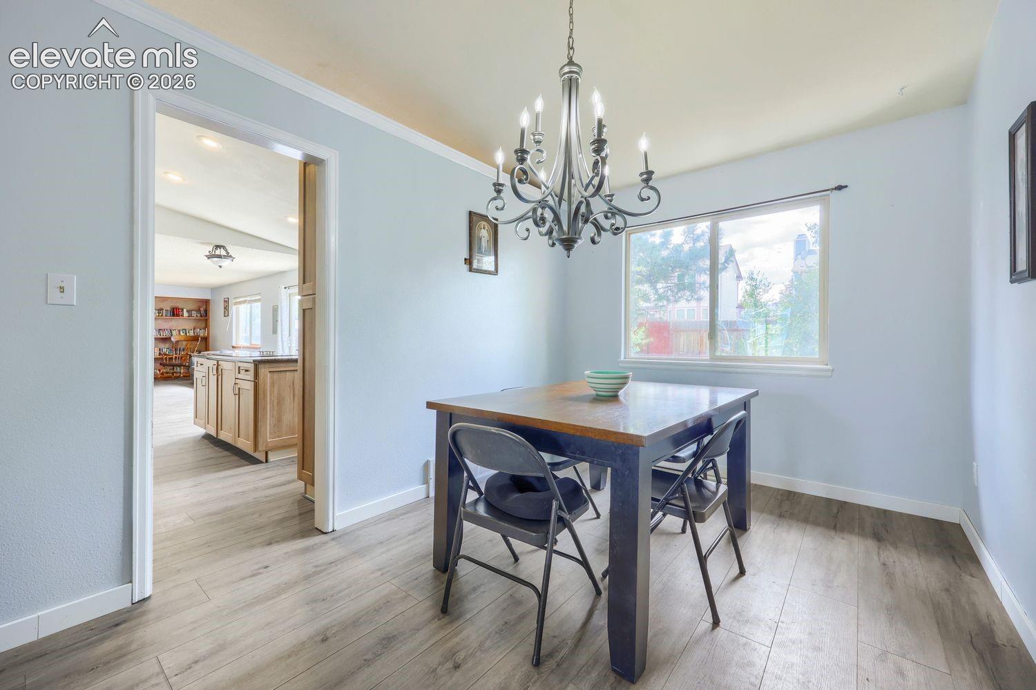 Wood-finish flooring throughout, with a classic chandelier fixture and white trim