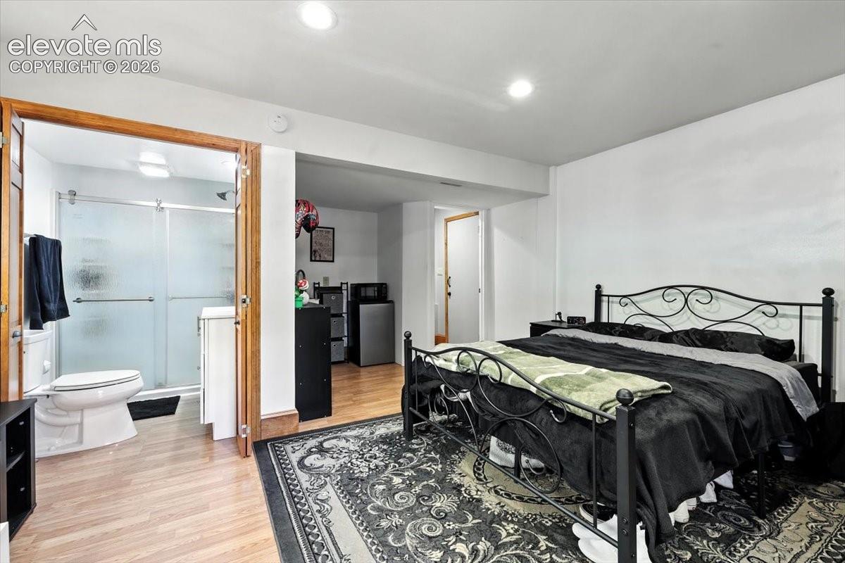 Interior space featuring wood-finish flooring, recessed lighting, and a bathroom equipped with a glass-enclosed shower