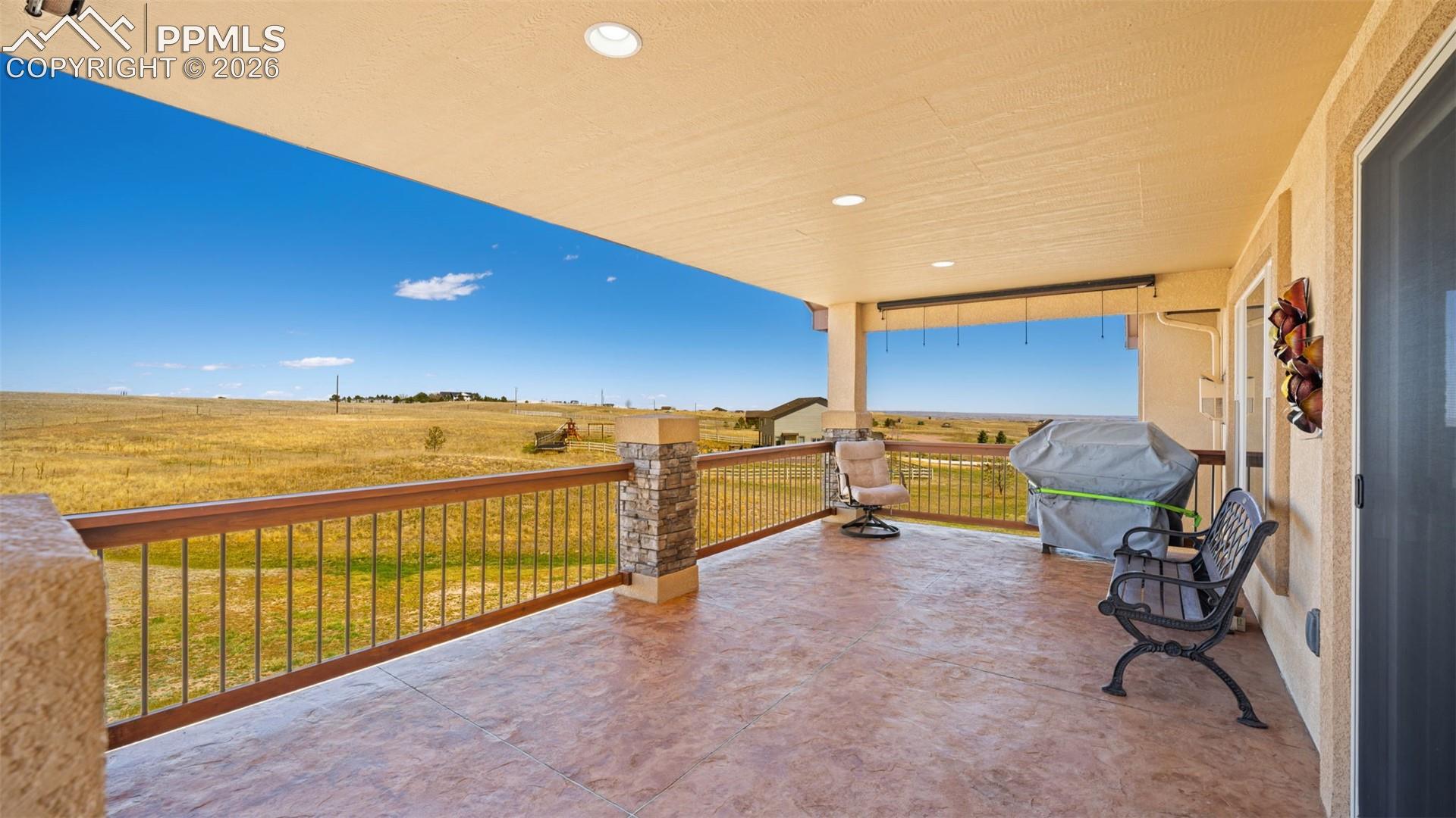 View of low maintenance, stamped concrete covered deck with a view of countryside