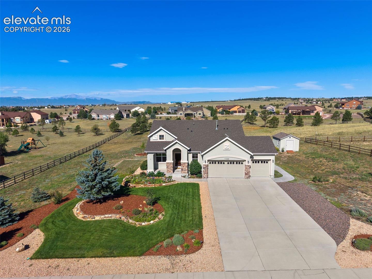 Incredible ranch floor plan on 1.4 acres w/ mountain views, beautiful landscaping & a finished basement! Pride of ownership shines from the moment you arrive w/ custom stone landscape walls, lush sodded front lawn, mature evergreens, bushes & an impressive variety of perennial flowers. Timed sprinkler/drip systems help maintain the lawn, trees & plantings, while a concrete walkway provides convenient access from the front to the rear patio. Step inside to soaring 11’ ceilings in the main living areas & hardwood floors extending from the entry through the kitchen. The spacious living room is filled w/ natural light & features a gas fireplace w/ large mantle plus conduit for TV/cable. Open kitchen offers abundant cabinetry, granite counters, center island, tile backsplash & SS appliances including Maytag flat cooktop, microwave & dbl ovens plus NEW Maytag dishwasher Dec 2025. Nearby dining space enjoys backyard views & access to the rear patio. Main level office w/ French doors provides an ideal dedicated workspace. Generous primary suite features vaulted ceiling & private bath w/ long vanity, soaking tub, separate tiled shower, architectural niches & abundant natural light. The finished lower level w/ 8’ ceilings delivers an incredible amount of flexible living/entertaining space plus wet bar & 5 ceiling-mounted speakers for theater effect. Plenty of room for recreation, movies, games & additional gathering space! Additional highlights include Central Beam home vacuum system & a 12’x16’ wood-construction shed, stuccoed to match the home & set on a concrete pad. Enjoy the large rear patio, wide-open outdoor space and wonderful western views showcasing dramatic storms, colorful sunsets, clouds & the mountain range. An exceptional combination of acreage, indoor/outdoor space, views & versatility—this spectacular property is a must see!