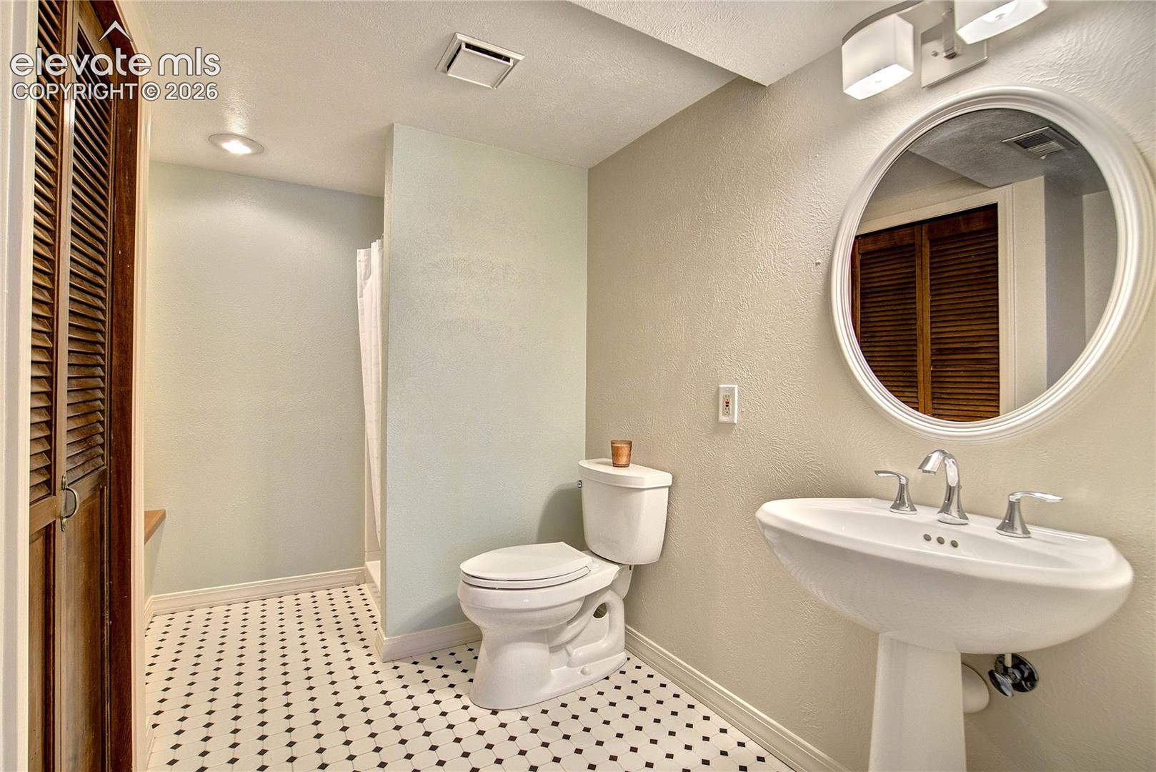 A private lower-level bath complements the additional bedroom + flexible living spaces.