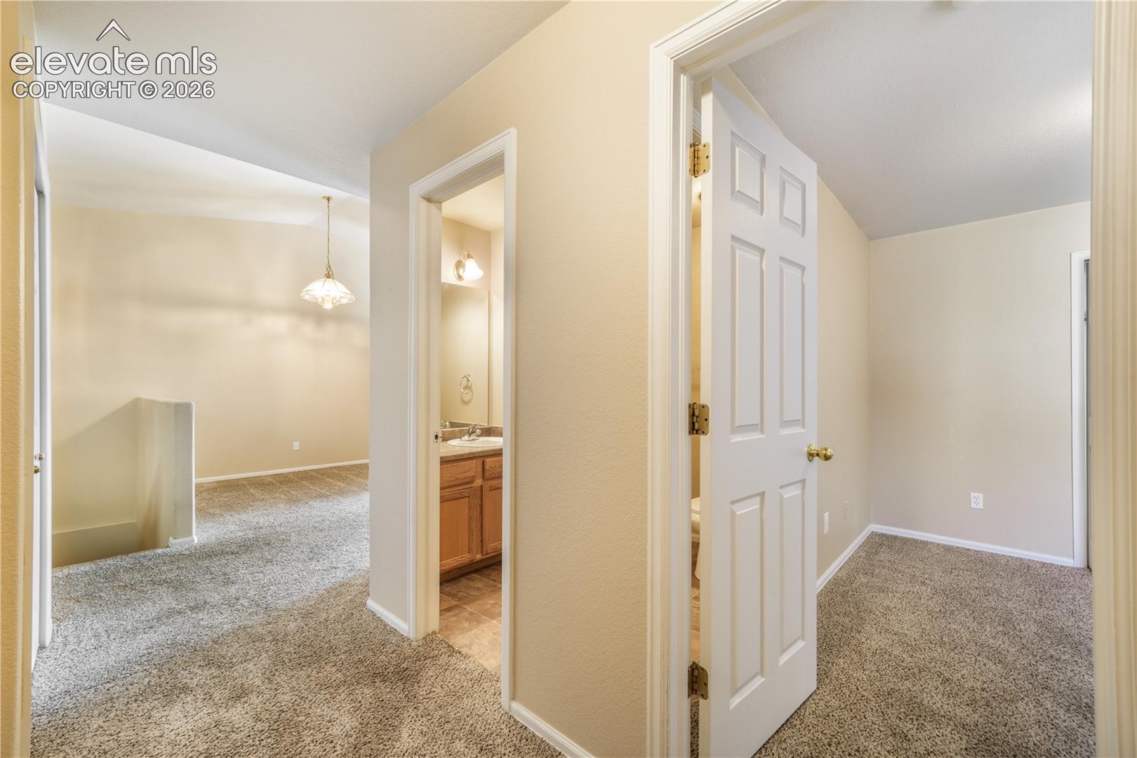 Hallway view of first bedroom, main floor at front of home with connecting access to the 3/4 bathroom