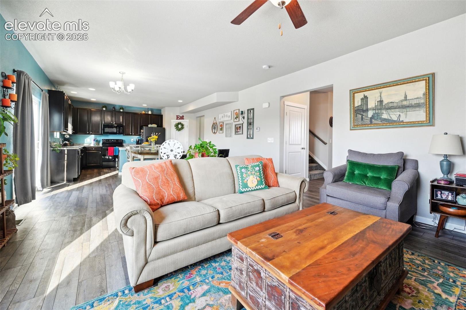 Open-concept floor plan featuring dark wood-finish cabinetry, wood-finish flooring, and a ceiling fan