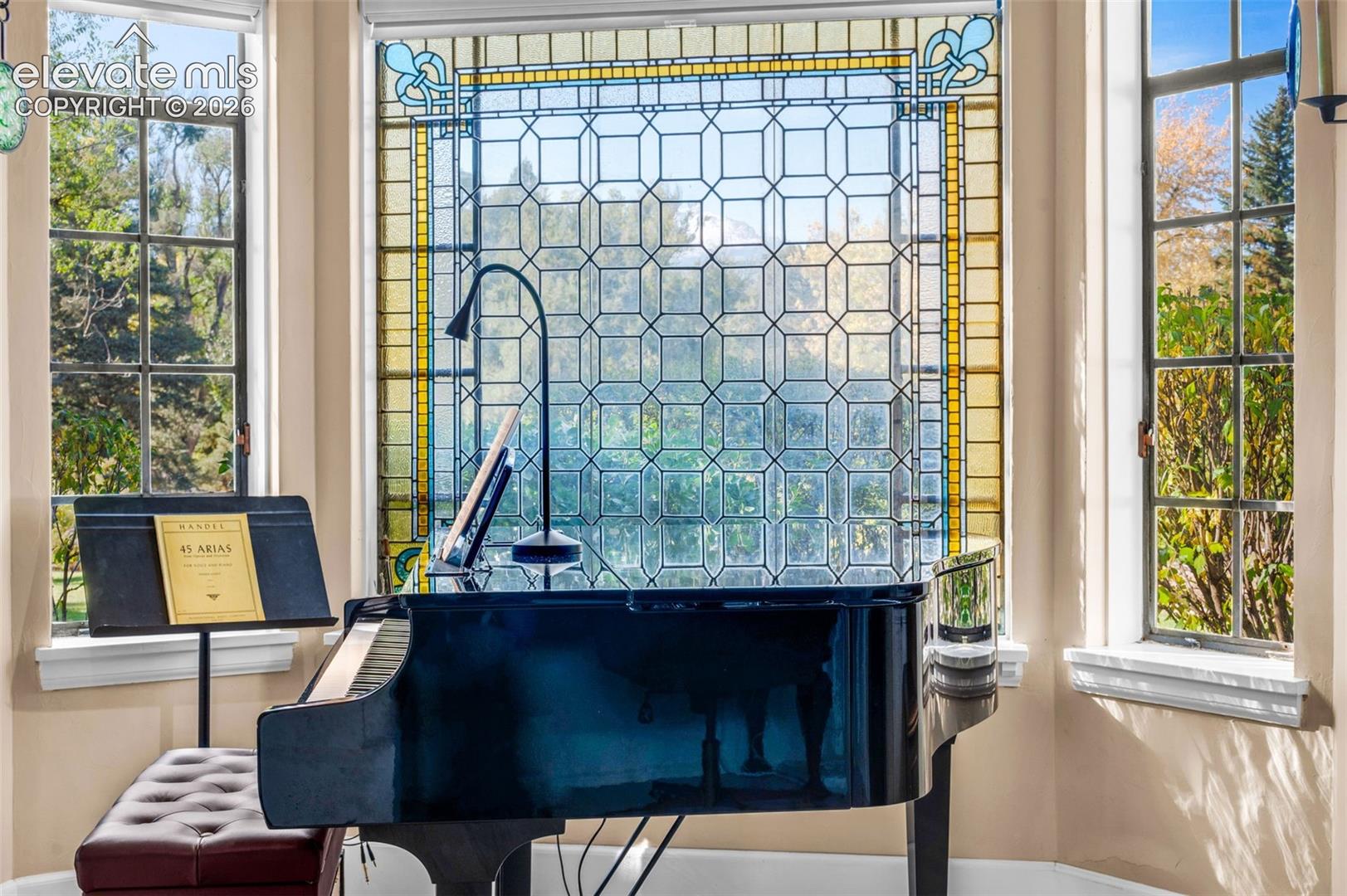 Bay window featuring intricate custom stained-glass detailing and multi-pane casement windows