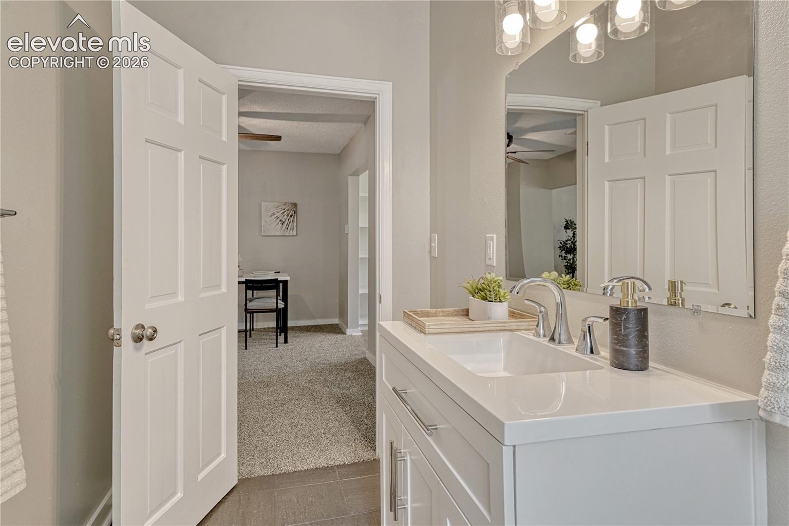 Dual-sink vanity with white cabinetry, quartz countertop, and polished chrome fixtures