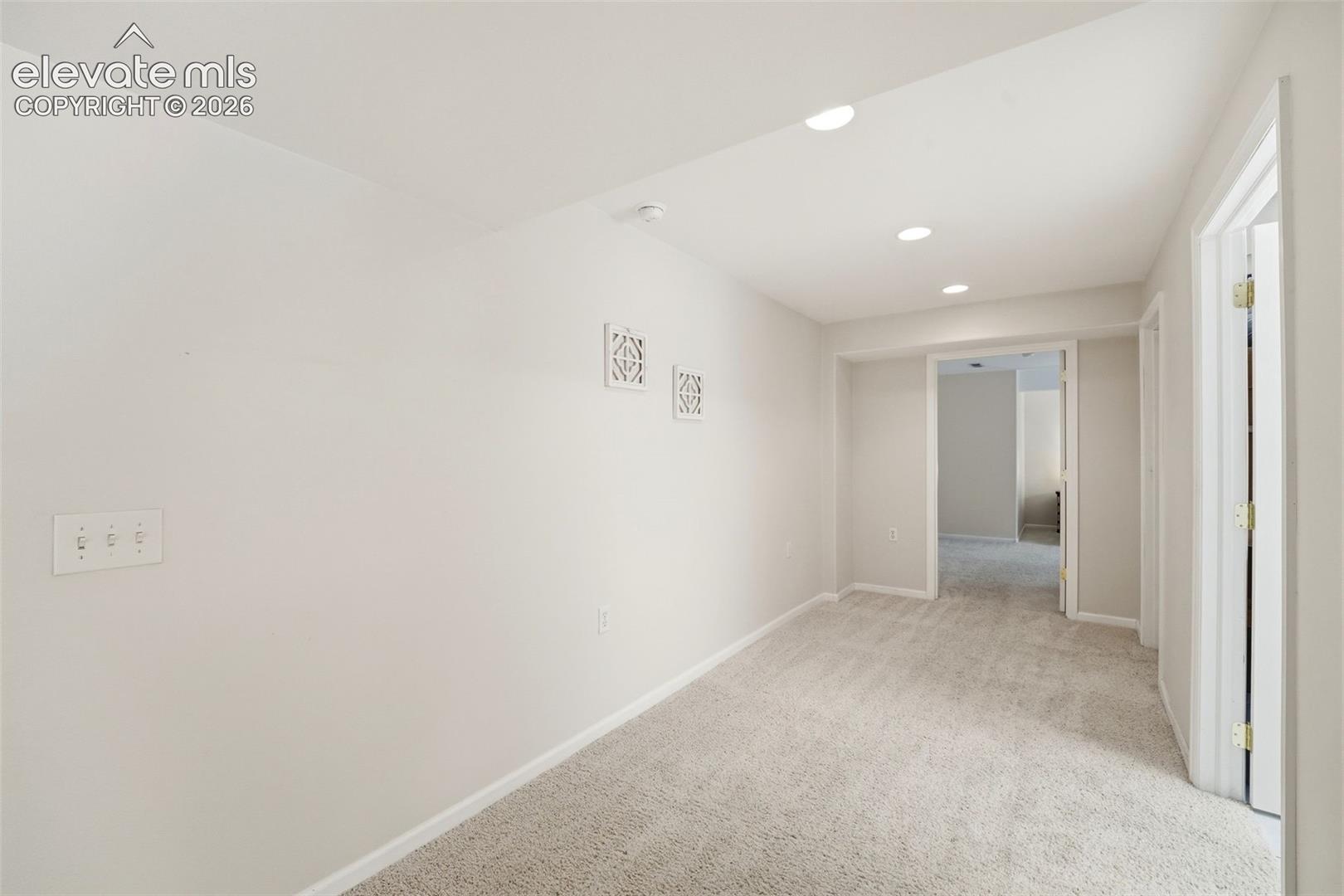 Generous hallway connecting the expansive lower-level living spaces