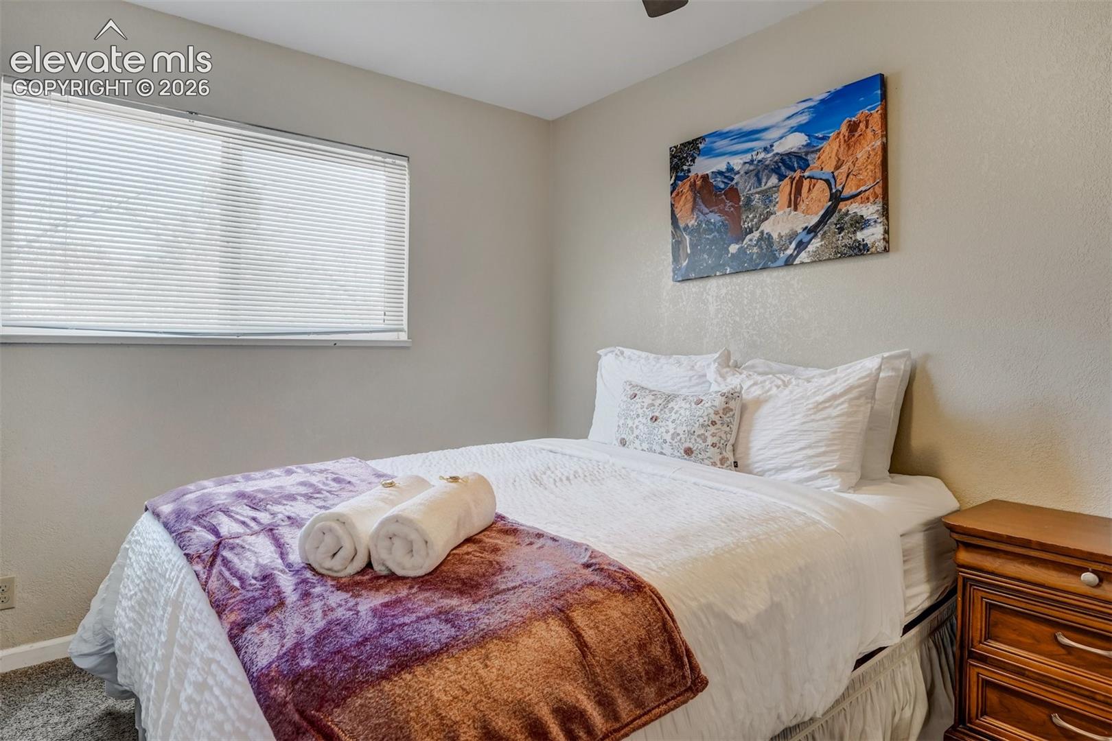 Recessed window with blinds, textured walls, and a ceiling fan