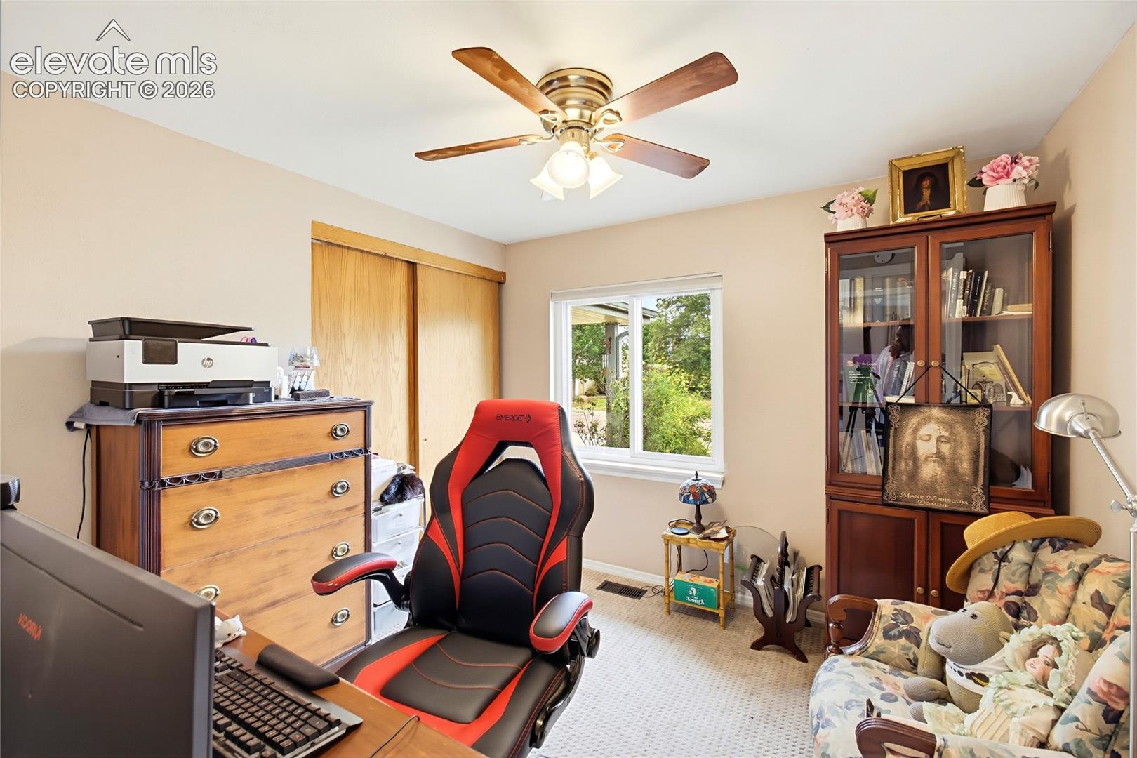 Recessed window, wood-finish sliding closet doors, ceiling fan with integrated lighting, and neutral wall tones