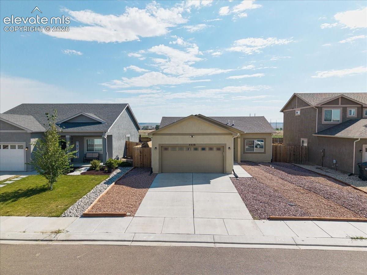 Single-story residence featuring an attached garage, concrete driveway, and gravel landscaping