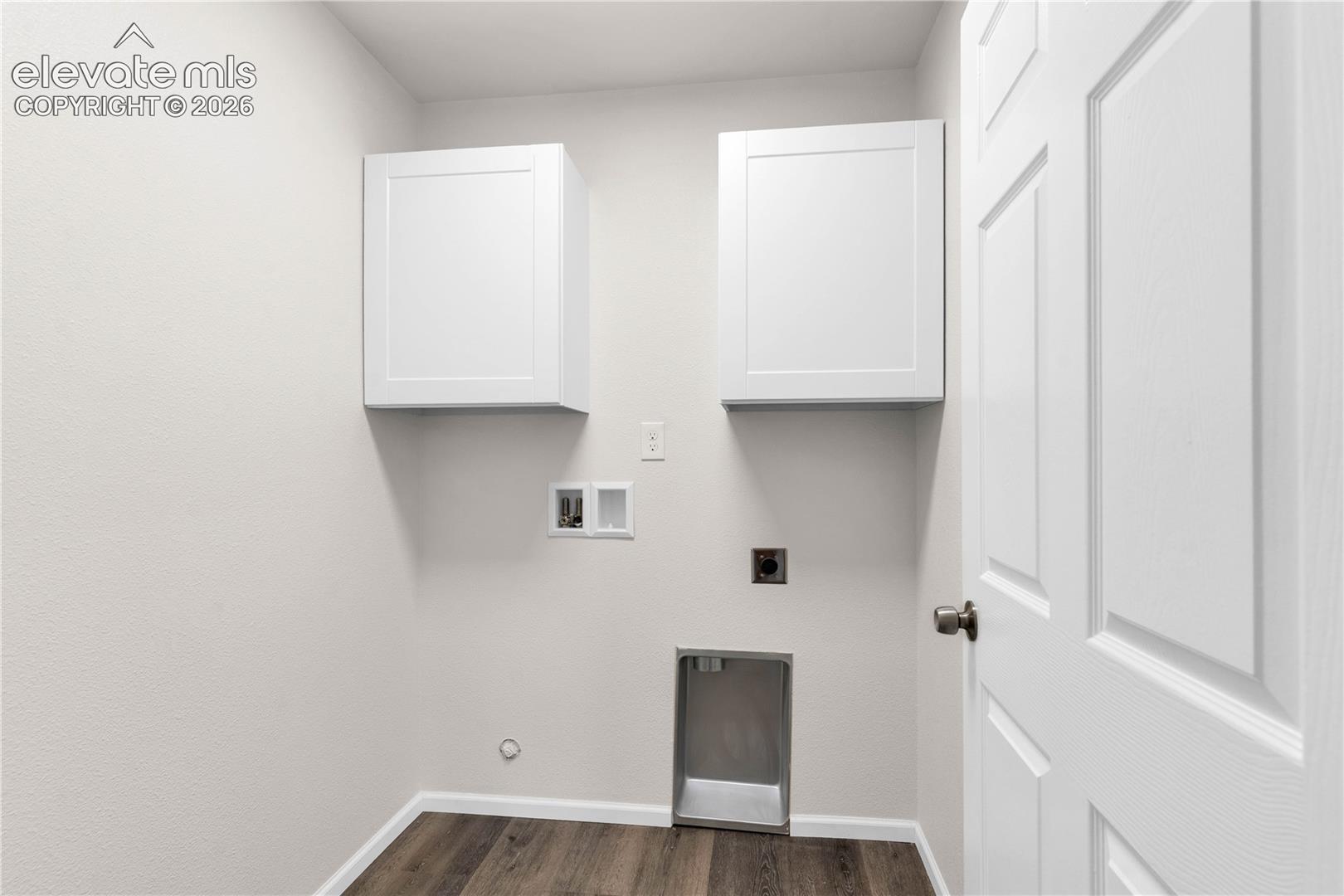 Utility space featuring wall-mounted shaker-style cabinetry, wood-finish flooring, and recessed laundry hookups