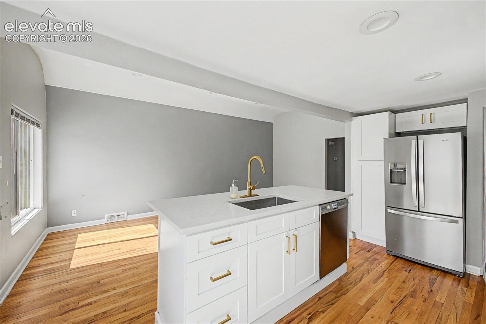 Primary bedroom featuring hardwood flooring, light gray walls and h