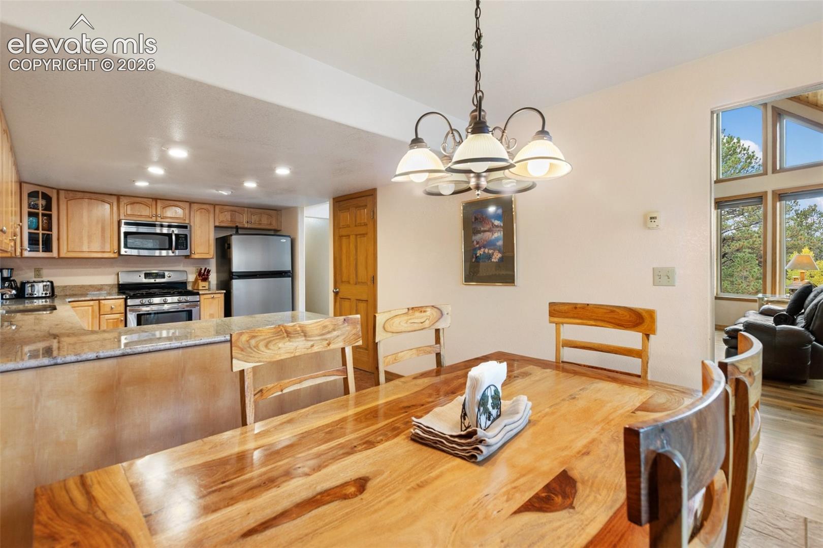 Kitchen featuring wood cabinetry, stainless steel appliances, and granite countertops