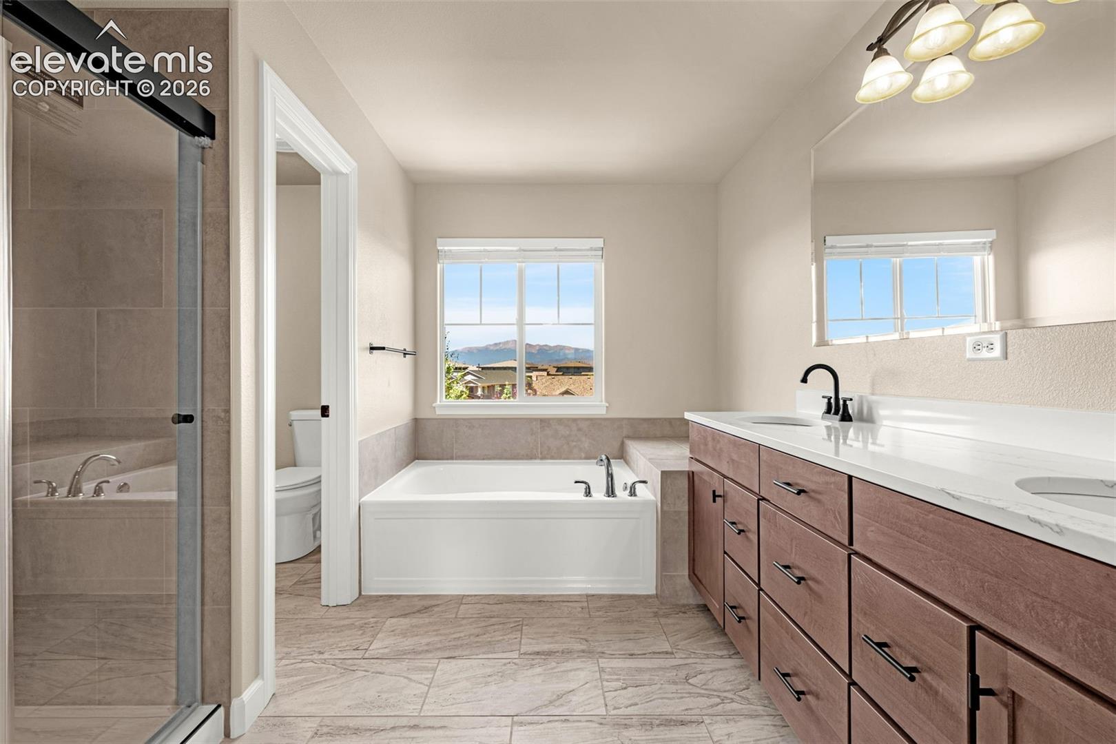 Primary bathroom has new tile flooring, new cabinets, new quartz counters, new fixtures, new blinds, new tub, new stand alone shower and stunning views of Pikes Peak.  