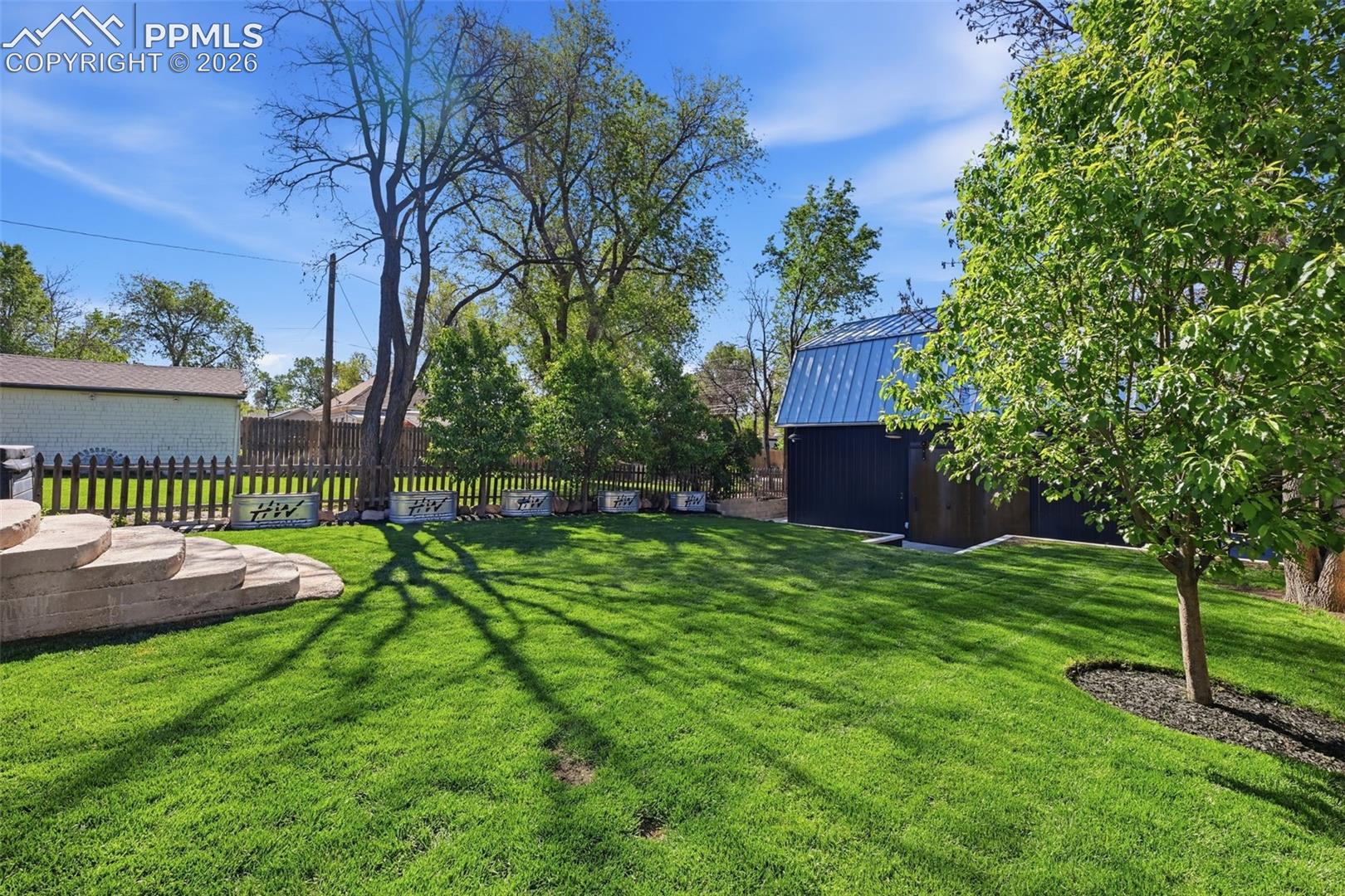 The backyard has auto sprinklers and a dripline to the garden beds.