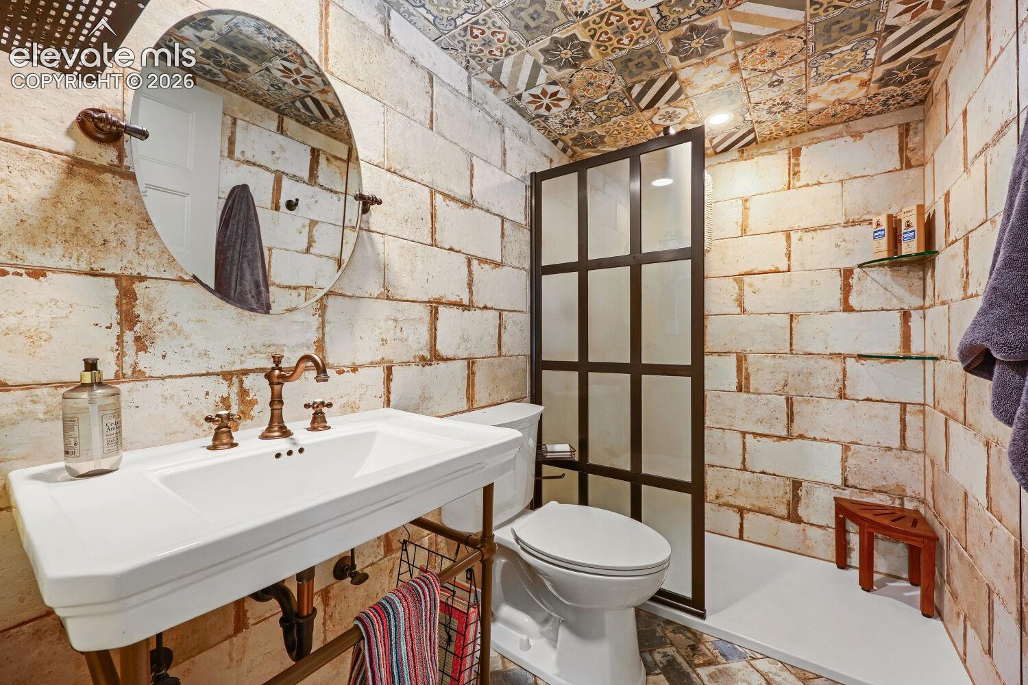 White rectangular sink with an oil-rubbed bronze faucet, set against a distressed brick-patterned wall