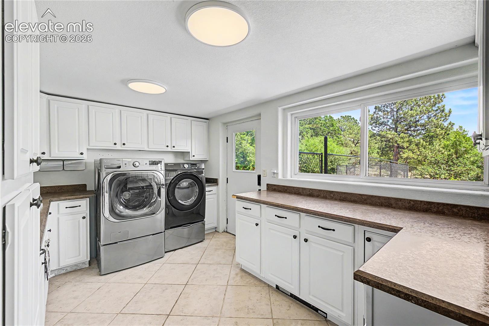 The laundry room is generously sized, with ample cabinetry, a window overlooking the backyard and a dedicated dog run.