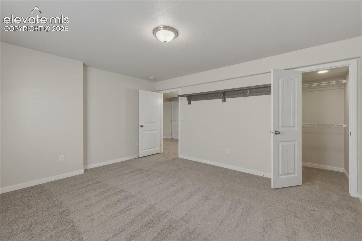 Bedroom with walk in closet and built in custom shelving. 