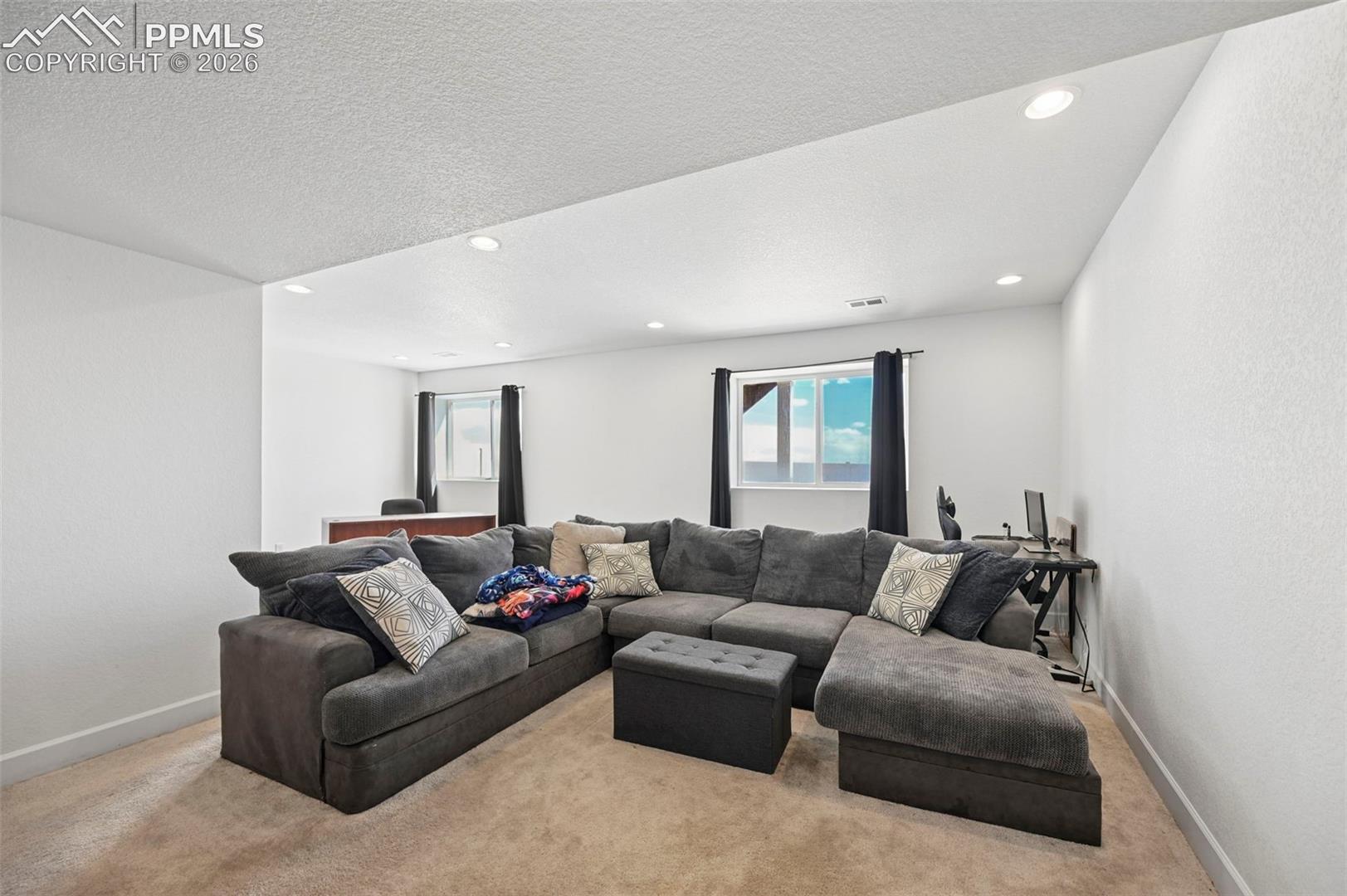 Spacious room with plush carpet flooring and recessed lighting