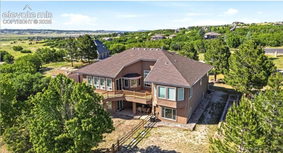 Two-story residence with a multi-level deck, lower patio, and extensive window placement