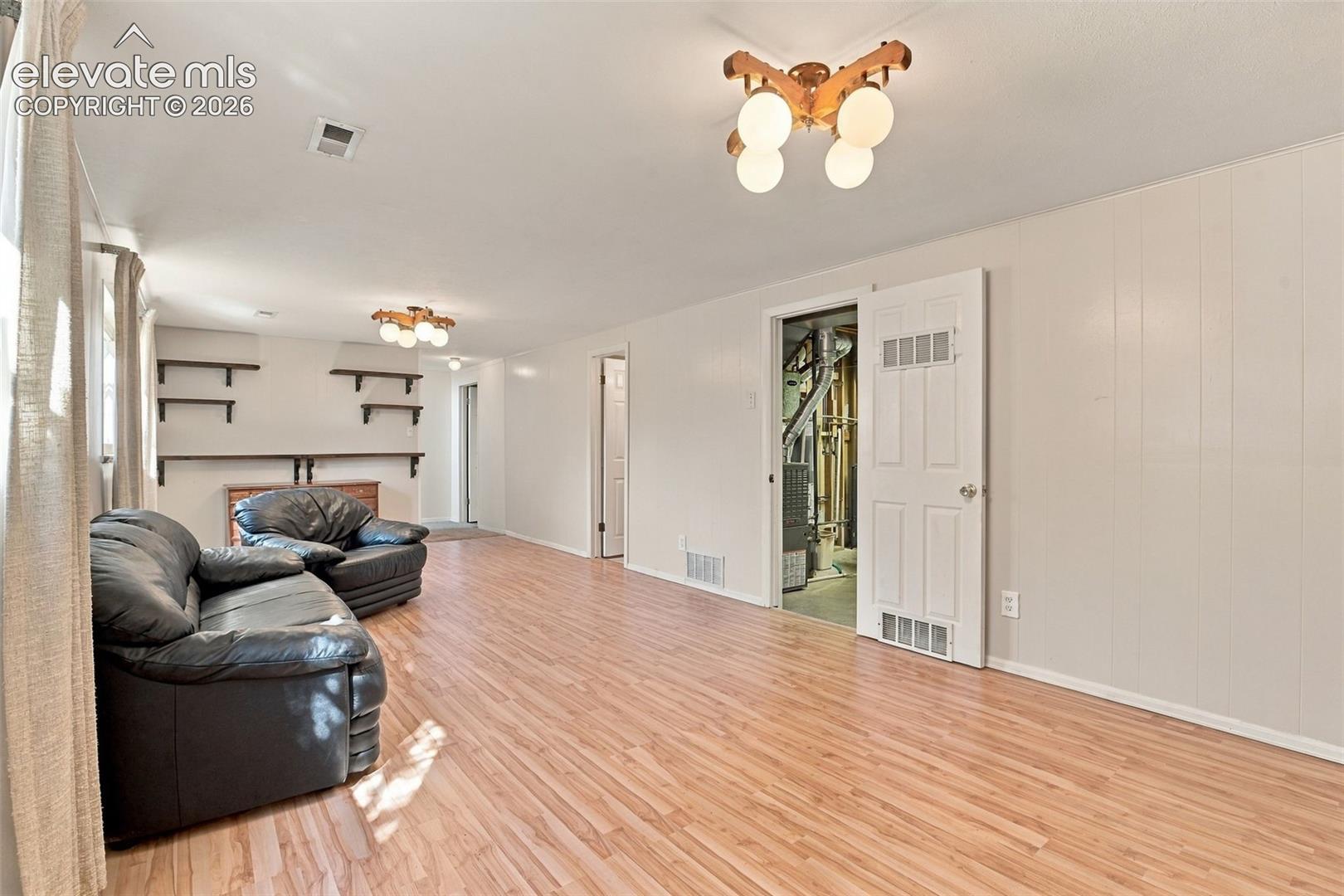 Wood-finish flooring, multi-arm globe lighting fixtures, and wall-mounted shelving units