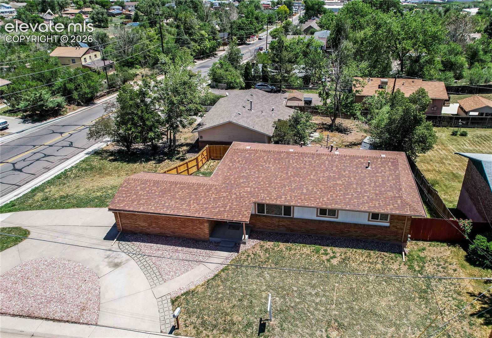 Single-story brick and siding exterior featuring an asphalt shingle roof, concrete driveway, and stone-accented walkway