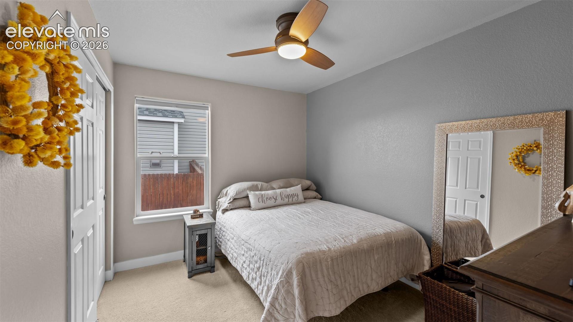 Neutral interior paint, plush carpeting, double-panel closet doors, single-hung window, and a three-blade ceiling fan with an integrated light fixture