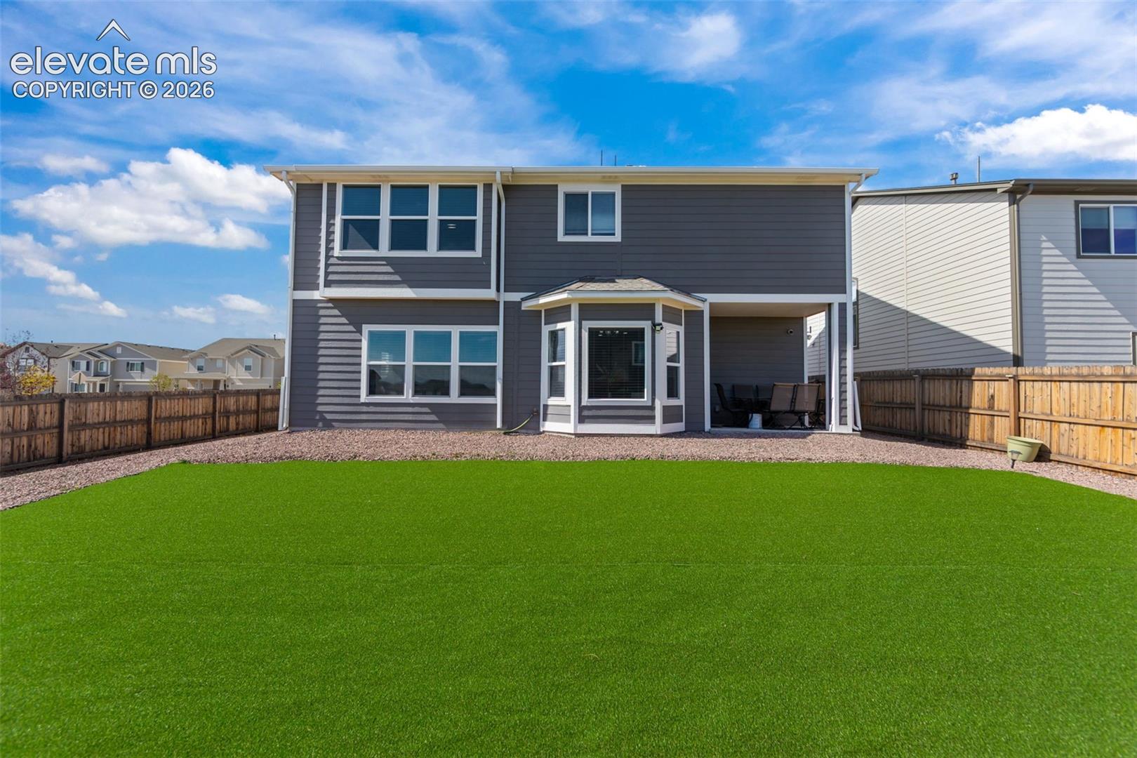 Expansive backyard featuring a green lawn and gravel border