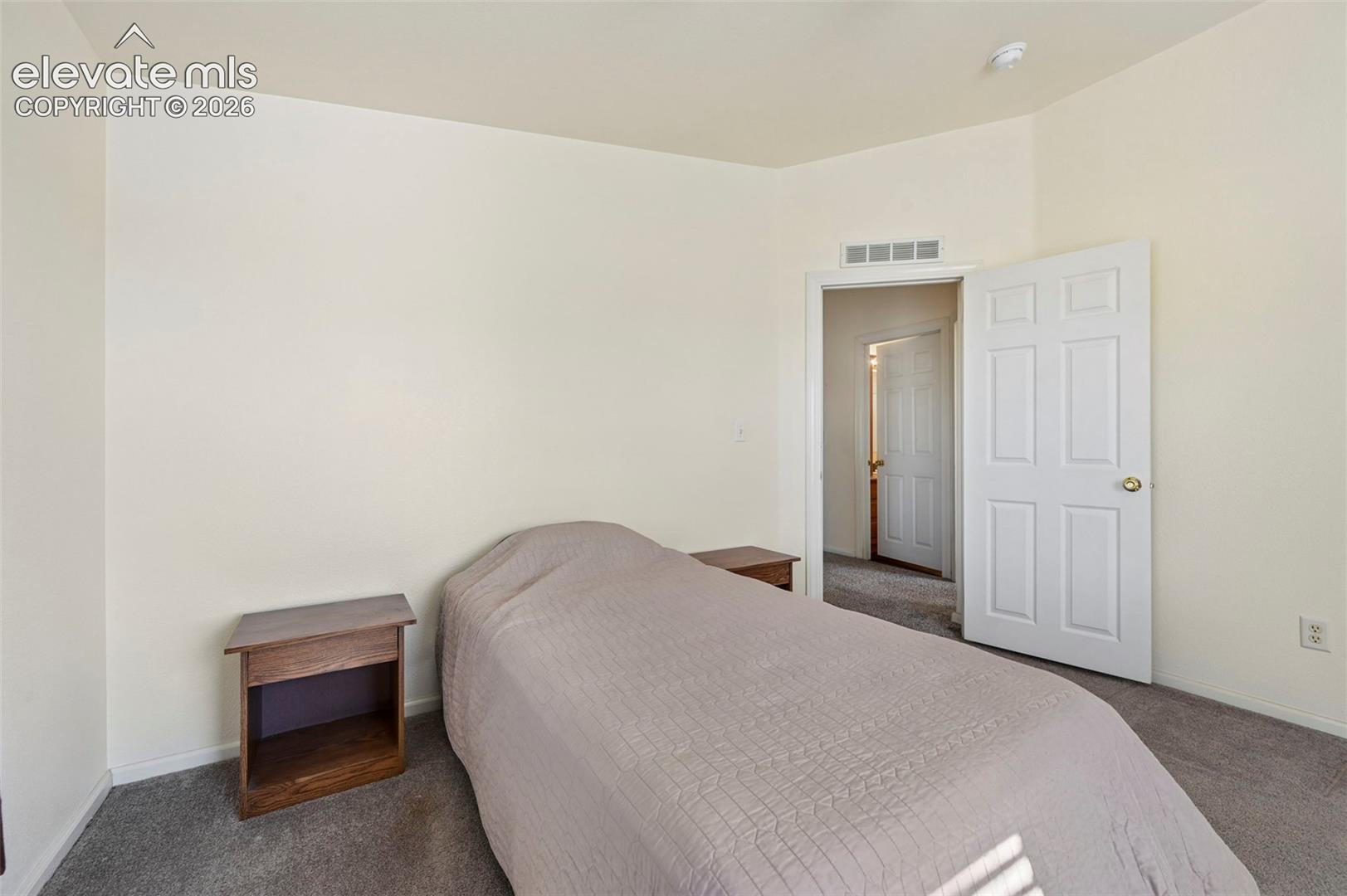 Neutral interior featuring wall-to-wall carpeting and a traditional six-panel interior door
