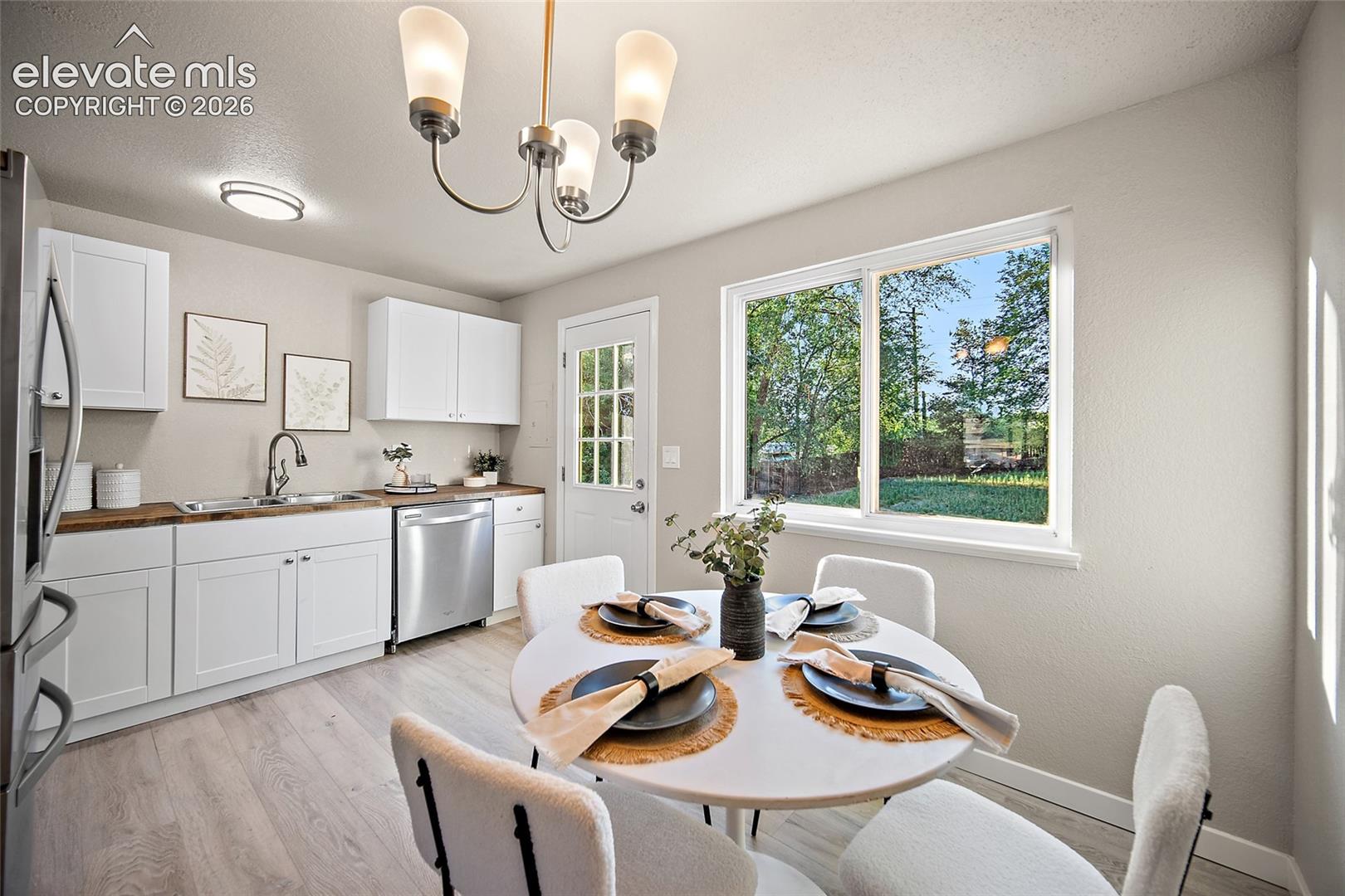 Kitchen featuring white cabinetry, wood-finish countertops, stainless steel appliances, and wood-finish flooring