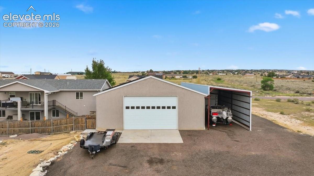 Back of garage with road and oversized garage door.