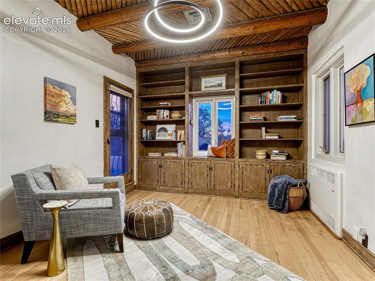 Primary Suite sitting room has built-in bookcases with hand-carved, hand-painted detail and access to roof for potential private outdoor space.