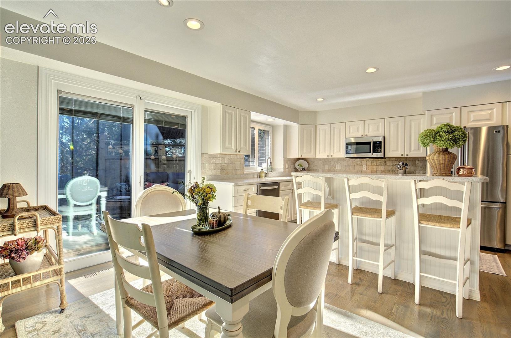 Sunlit breakfast nook with direct access to the Ipe deck + views toward Cheyenne Mountain.