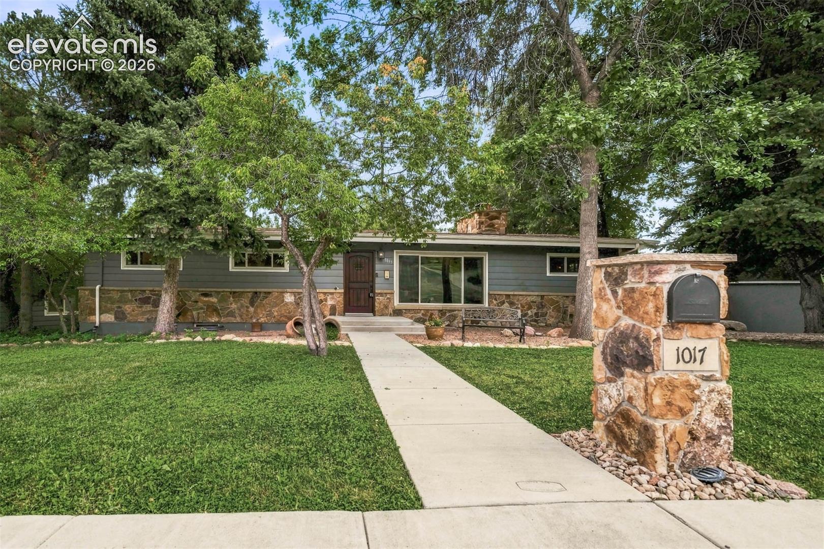 Welcome to this beautiful ranch style home in the heart of Lower Skyway. This charming home is a unique property with exterior stone accents, a nice grass and treed lot, and a concrete walkway. With a welcoming and functional layout and lots of entertainment space on both the main level and the lower level. Upon entering the home, you immediately notice the hardwood throughout the main living area, the beautiful fireplace, remodeled kitchen with granite countertops and stainless-steel appliances, custom bookcases with secret compartments and wood shutters. The large primary bedroom has enough space for a full bedroom furnishing and a sitting area. There is a second bedroom on the main level. The open concept living area flows into the kitchen and dining room space with a walkout to the entertainer's paradise. With abundant outdoor entertainment space, to include; a built-in gas firepit, a built-in kitchen with gas grill and granite counter tops, stamped concrete, a large, covered deck and connections for TV/surround sound. There is an oversized 2-car detached, heated garage, 2 storage sheds, the backyard is completely fenced, and the mature trees allow for a wonderful outdoor place to enjoy year-round. Situated on a substantial corner lot, directly across the street from "The Little Dipper," swimming pool & walking distance to Skyway Elementary School. In addition to its prime location, it has numerous upgrades throughout the home including a new tankless water heater added in 2025, foundation reinforced in 2023, roof replaced in 2021 and new paint throughout the main level of the home. This home has been meticulously maintained and updated by the current owners.This is a Cheyenne Moutain gem that you do not want to miss!