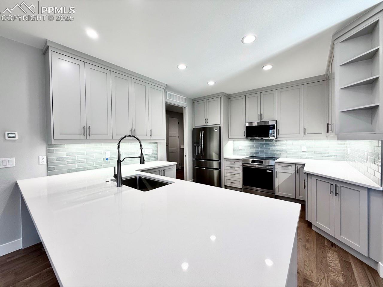 Full-sized Gourmet Kitchen with Quartz Countertops, Upper Cabinets to the Ceiling, Under-cabinet lighting., Induction Range, Included Stainless Still Fridge, and Wood Flooring.