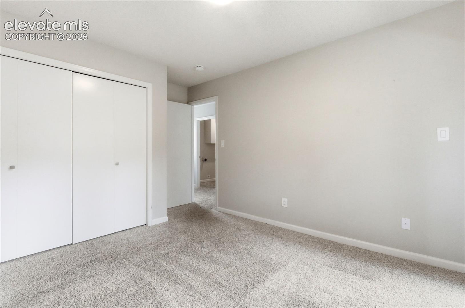 Neutral-toned walls complement the light gray carpeting
