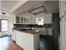 Kitchen featuring white shaker-style cabinetry, wood-surface island countertop, tile backsplash, stainless steel refrigerator, and recessed ceiling lighting