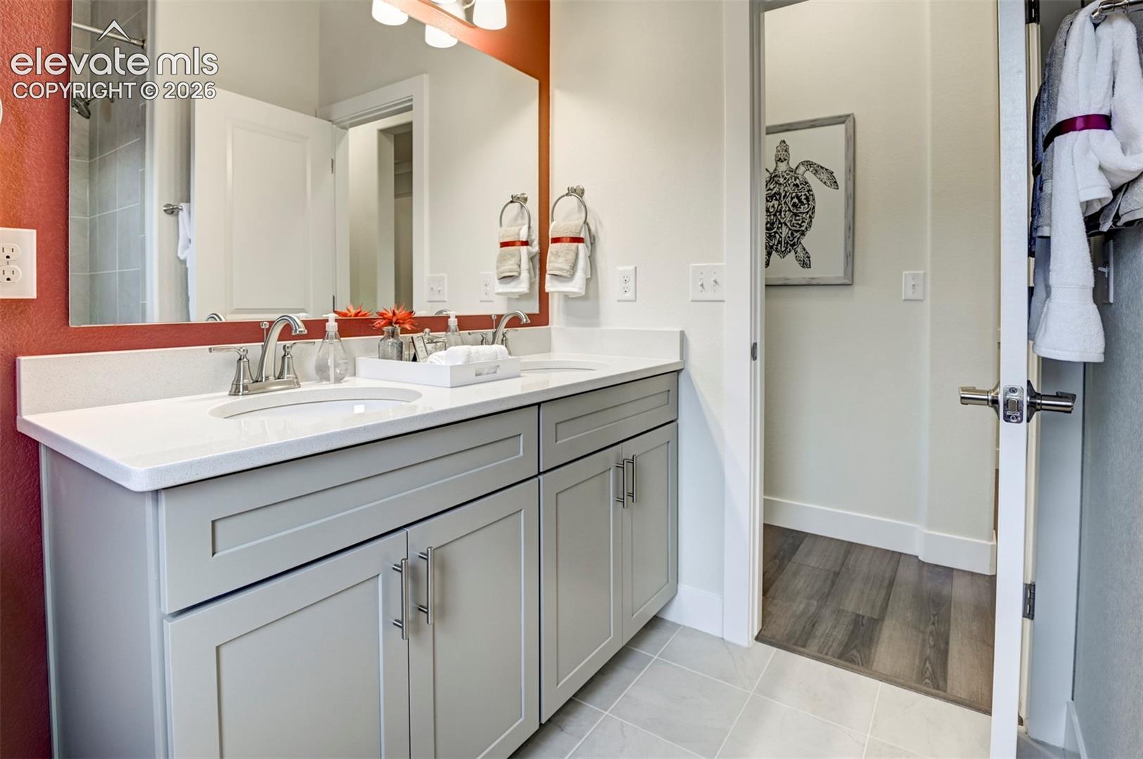 Double vanity with white countertop, chrome fixtures, and shaker-style cabinetry