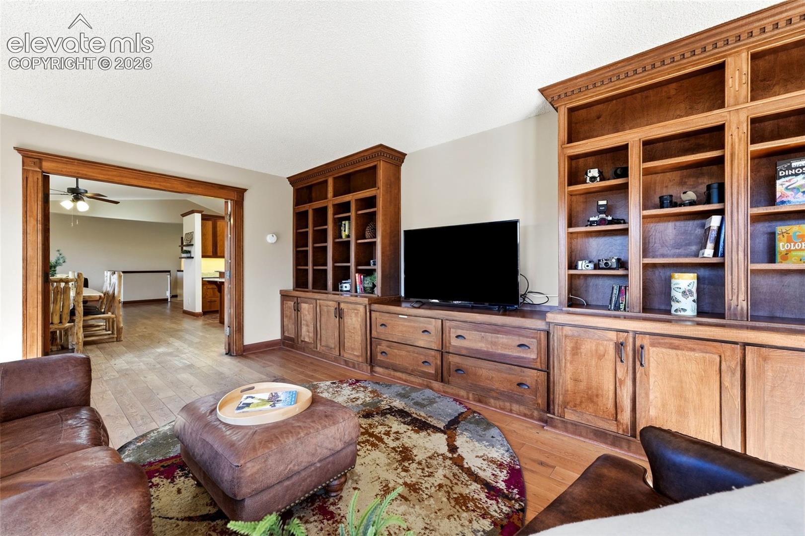 Built-in wood cabinetry with integrated shelving, wood-finish flooring, and recessed lighting