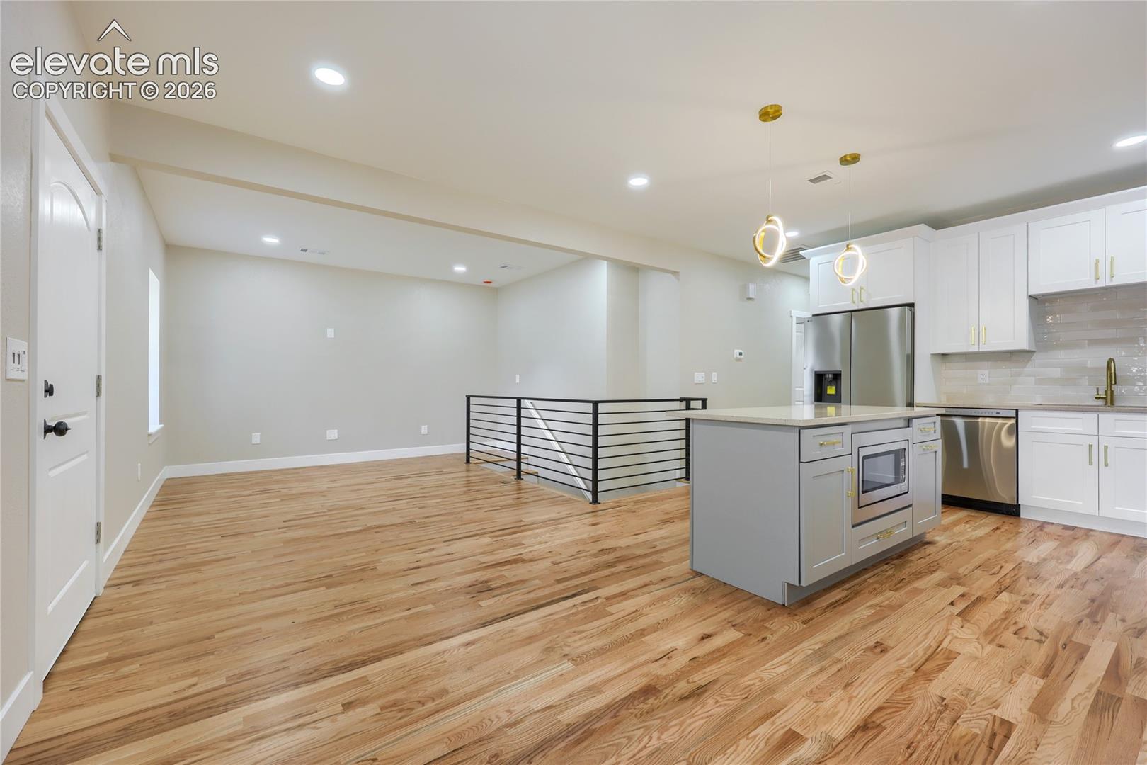 Another perspective of the living room, dining area and kitchen.