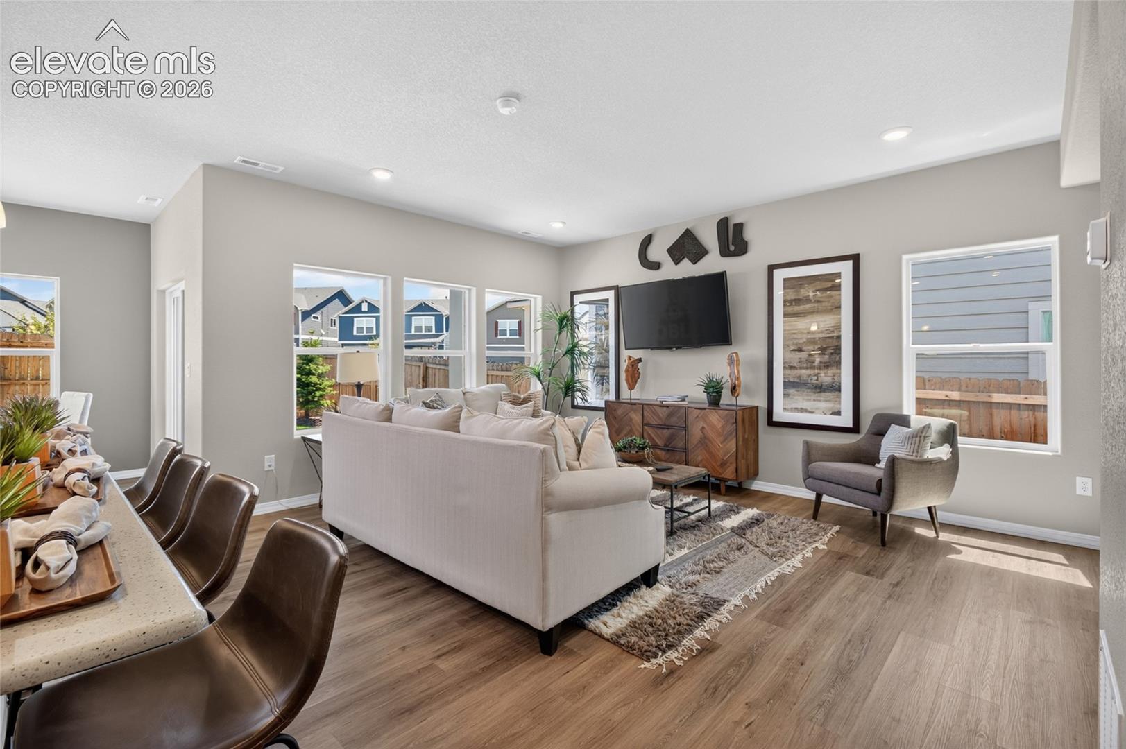Open-concept interior featuring wood-finish flooring, recessed lighting, and multiple large windows with exterior exposures