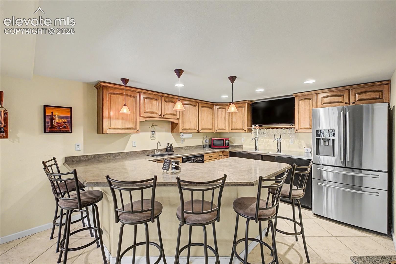 Rounded out with a built-in refrigerator and warm wood cabinetry, the bar area feels like a private pub tucked into the home.
