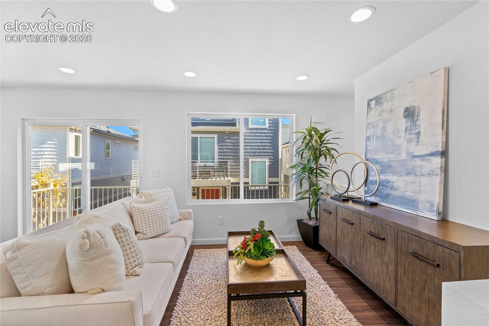 Recessed lighting, wood-finish flooring, white walls, built-in credenza, and a sliding glass door to a balcony
*photos of a model home*