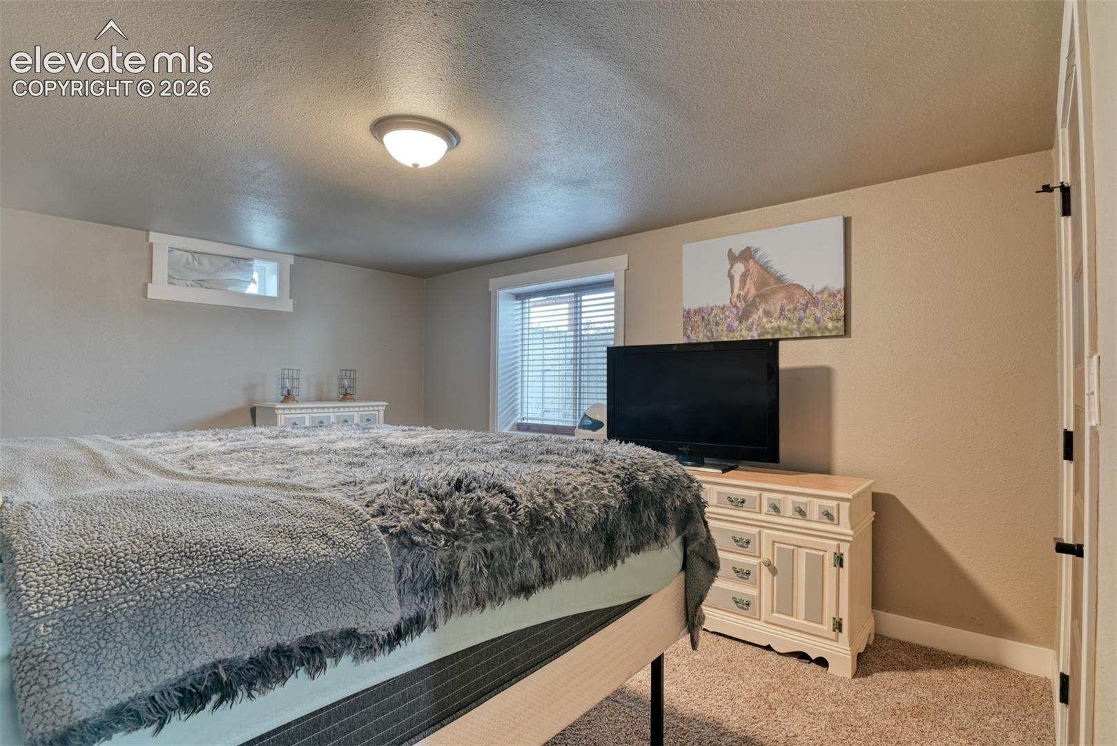 Bedroom with carpet floors and a textured ceiling