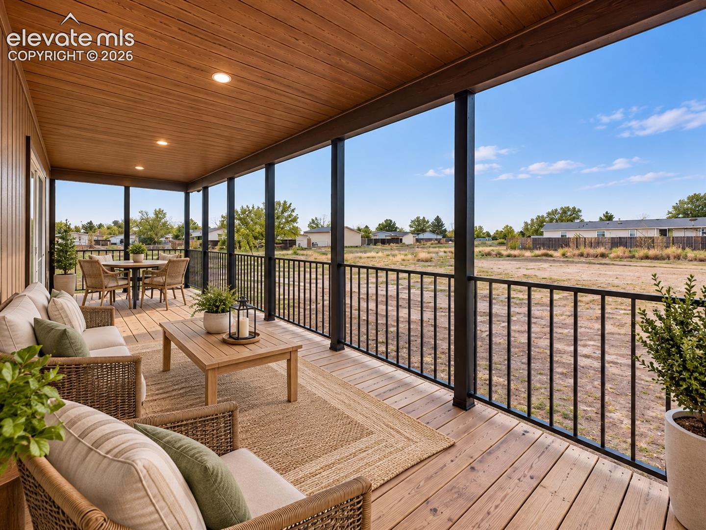 Covered Porch – Expansive covered porch provides abundant space for outdoor seating and dining, with recessed lighting, railing, and wide-open views beyond.