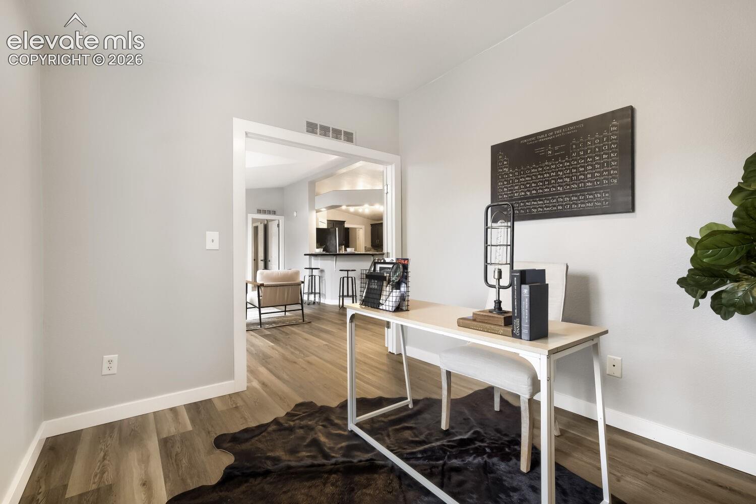 Neutral-toned interior space featuring wood-finish flooring, white door casing, and recessed lighting