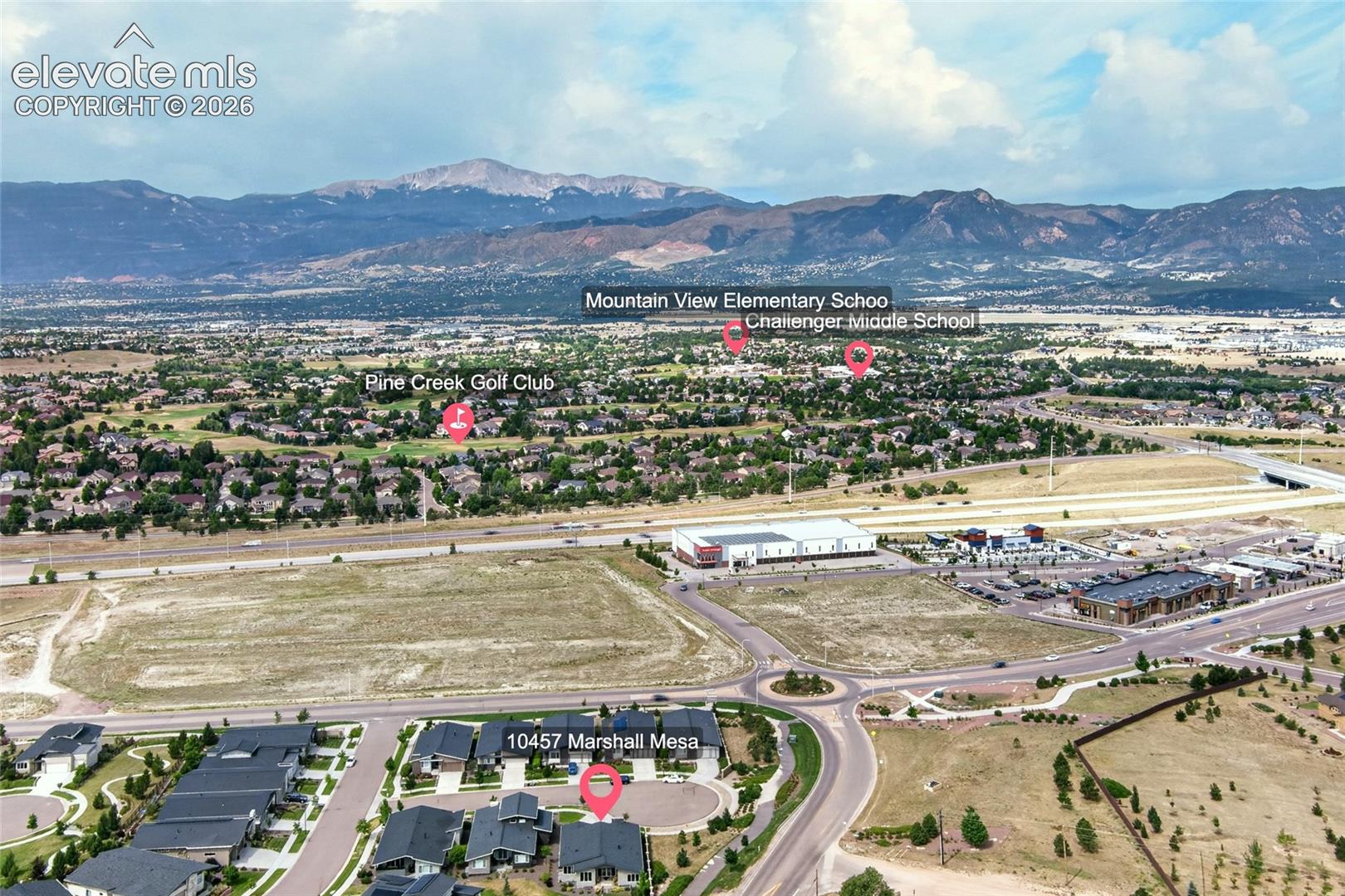 Aerial overview showcasing the community with prominent mountain ranges forming a scenic backdrop