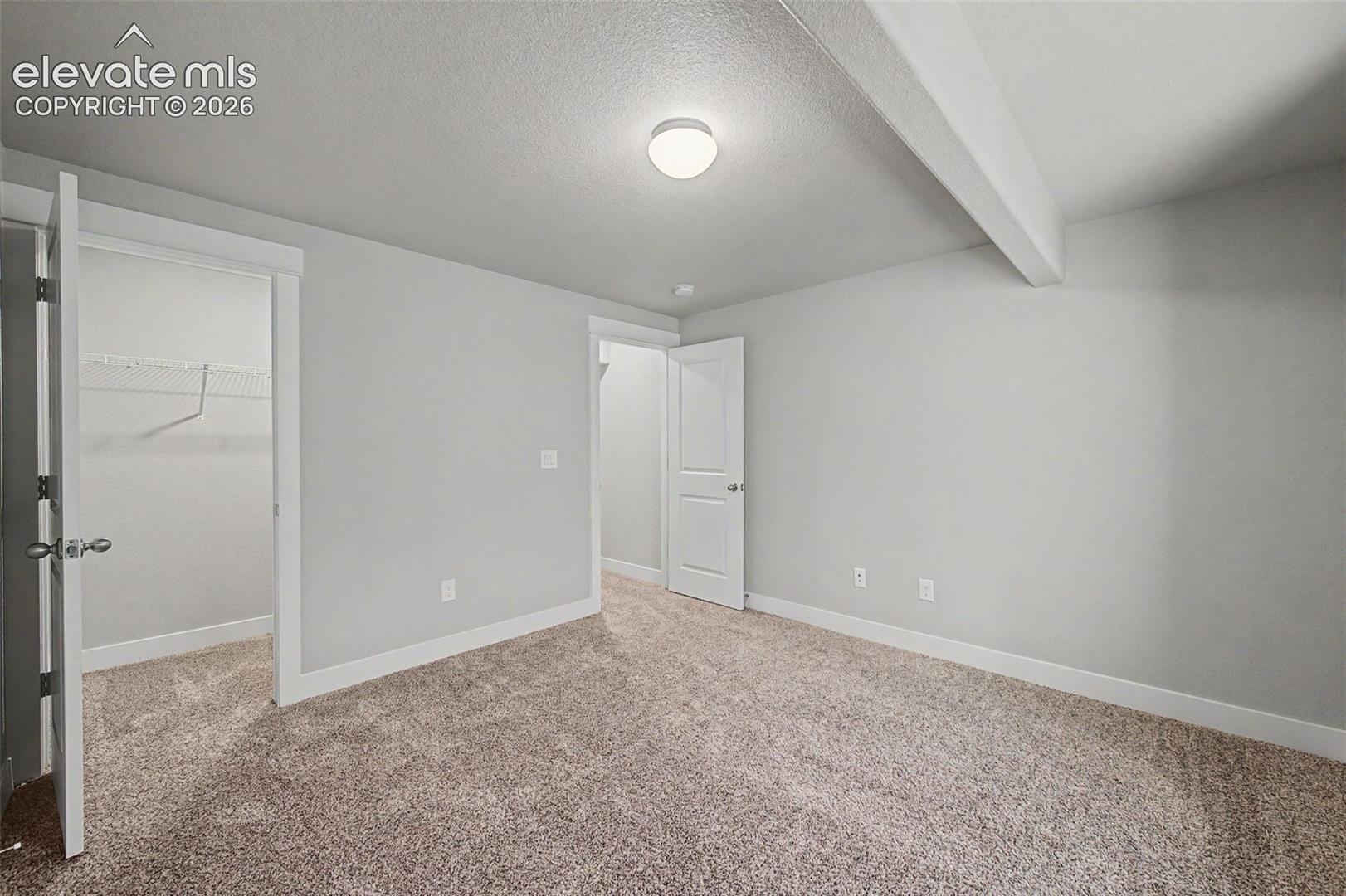 Neutral-toned wall-to-wall carpeting complements light gray wall finishes and white trim