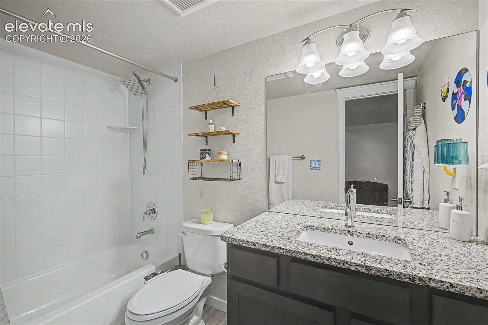 Basement full bath features a granite topped vanity.