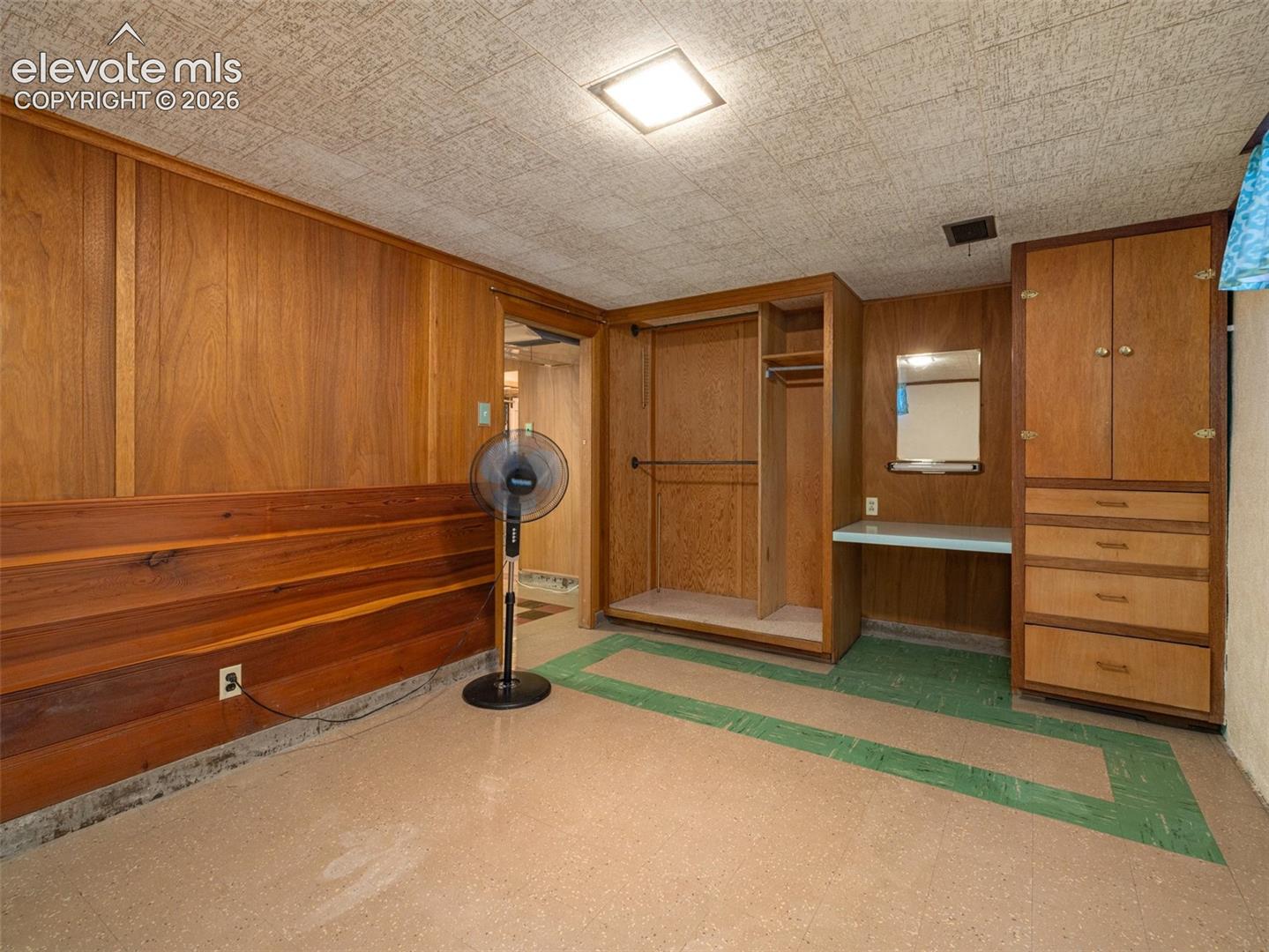 Wood paneling, built-in wardrobe cabinetry, integrated desk area, and recessed ceiling lighting