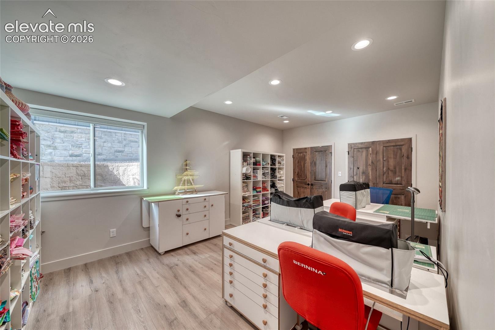 Interior space featuring recessed lighting, wood-finish flooring, and dual rustic-style wood-panel doors